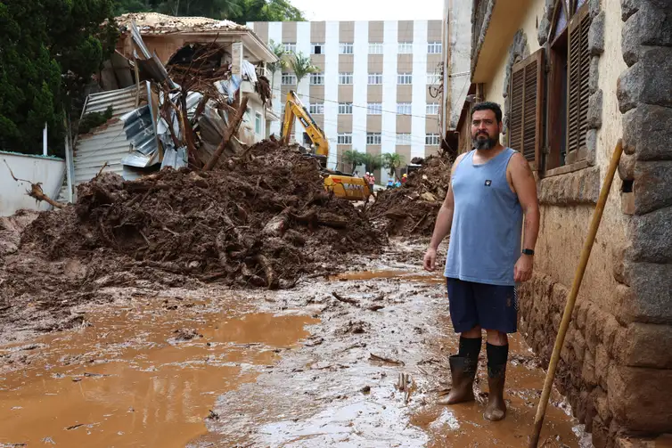 Juiz de Fora (MG), 27/02/2026 - Morador do bairro Paineiras, Guilherme Gouveia, ajuda na limpeza da lama trazida pelo deslizamentoto de terra, ocorrido durante a tempestade de segunda-feira, 23 de fevereiro, no Morro do Cristo.  Foto: Rovena Rosa/Agência Brasil